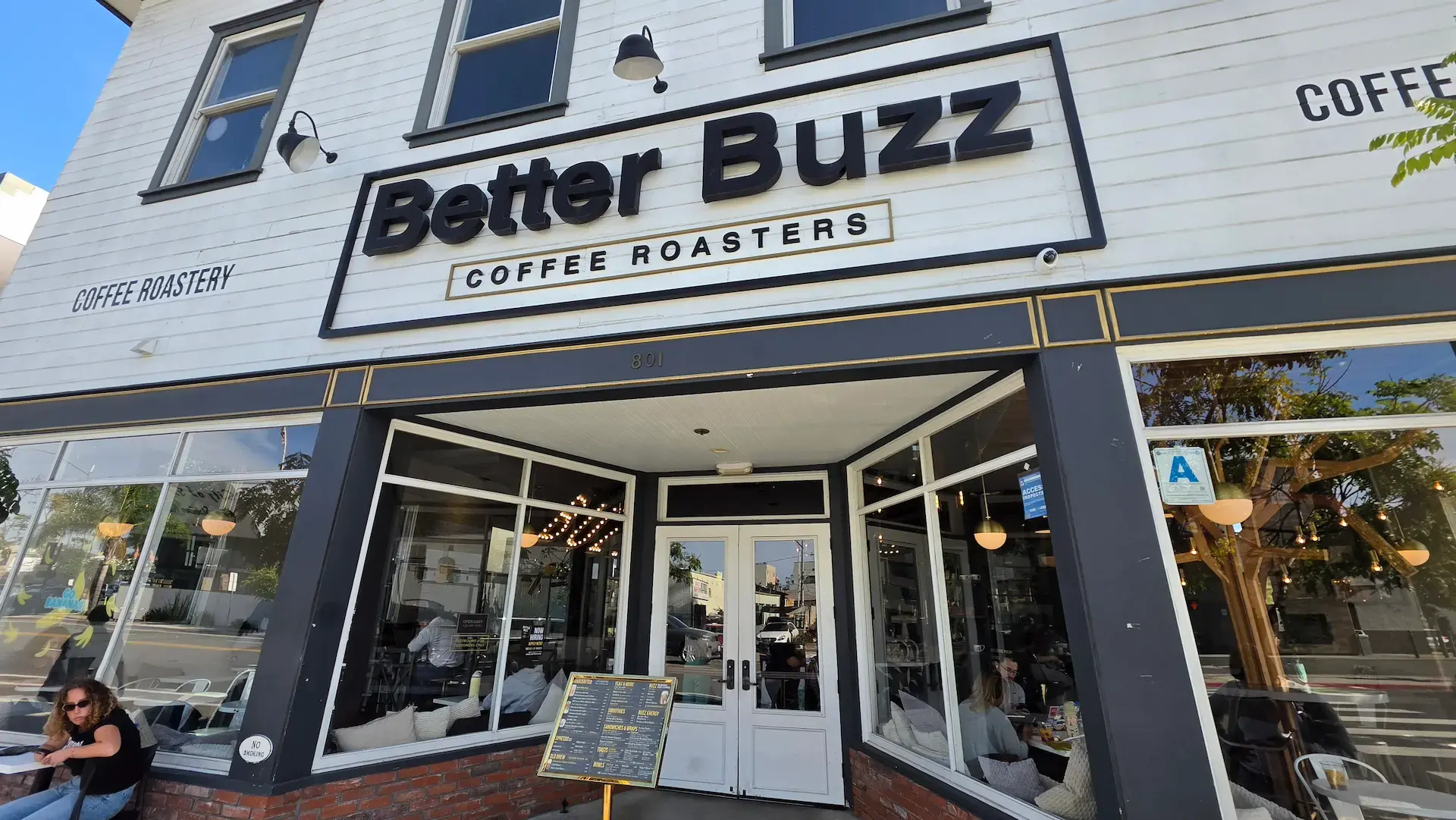 Better Buzz Coffee Roasters storefront on University Avenue in Hillcrest, San Diego — a two-story café with outdoor seating and string lights visible through the windows